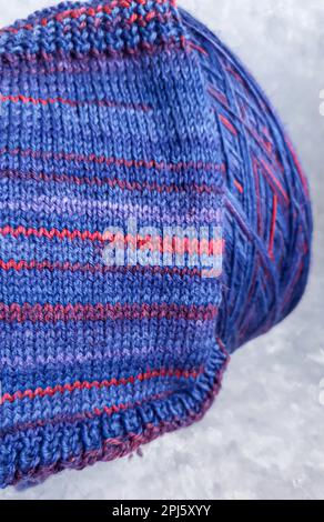 Handmade knitting pattern. Knitted fabric from a multi-colored thread and a large bobbin.Copy space Stock Photo
