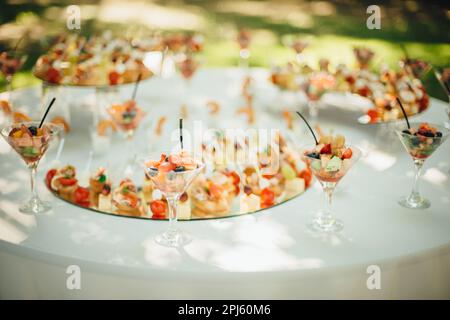 A rustic outdoor table setting featuring small plates of snacks during a wedding banquet Stock Photo