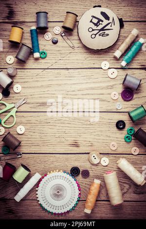 Sewing and craft tools - threads and buttons on wooden background in vintage style with free space for text Stock Photo