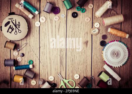 Sewing and craft tools - threads and buttons on wooden background in vintage style with free space for text Stock Photo