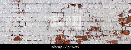 Old white painted brick wall with partly peeled paint Stock Photo
