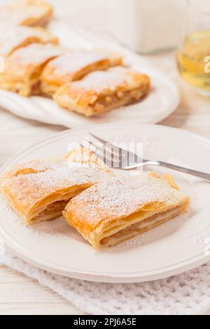 Homemade apple strudel (apfelstrudel) on white plate. Popular pastry cake in Europe Stock Photo