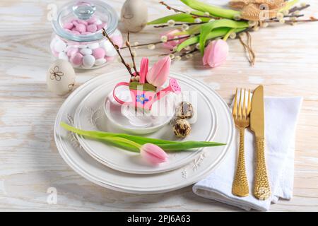 Place setting for Easter table with spring flowers. Easter table decoration Stock Photo