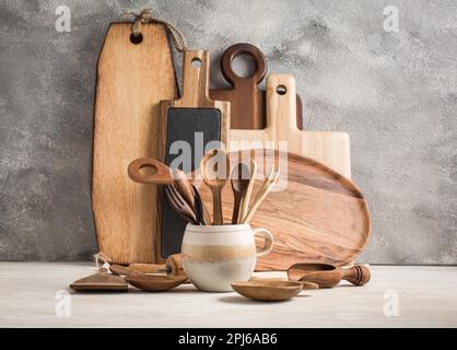 Assortment of wooden cutting boards and kitchen utensils on wooden background Stock Photo