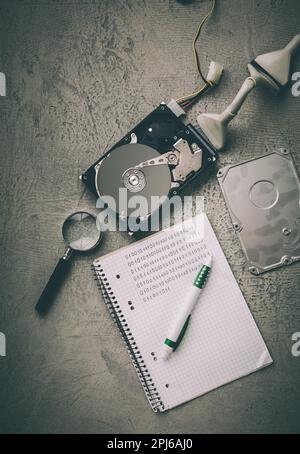 Concept of data recovery, reading data from corrupted hard drive. Hdd disk restoration, magnifier and binary code Stock Photo