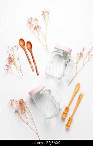 Empty drinking cups or jars with wooden spoons on white background. Plastic free lifestyle and concept Stock Photo
