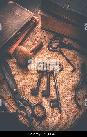 Old tools, books, keys and supplies on burlap in vintage style Stock Photo