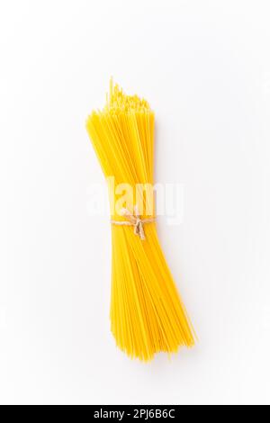 Spaghettini - thinner Spaghetti. Raw Spaghetti on white background Stock Photo