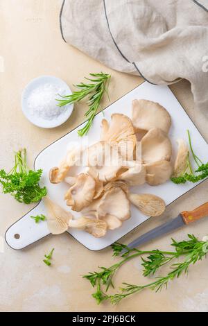 Organic oyster mushrooms with herbs and salt on cutting board Stock Photo