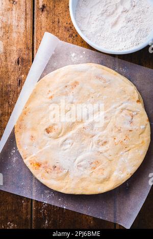 Flatbread, pita or pizza crust on wooden kitchen table Stock Photo
