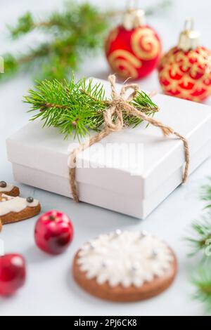 Christmas composition. Christmas gift, fir branches on wooden white background with gingerbread cookie Stock Photo