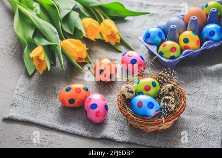 Spring time - Easter eggs and tulips on grey background Stock Photo