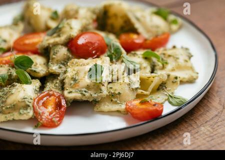Vegan Ravioli with Kale Walnut Pesto and Cherry Tomatoes Stock Photo