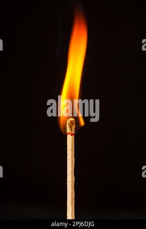 Burning matchstick on black background Stock Photo