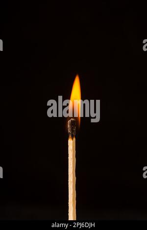 Burning matchstick on black background Stock Photo