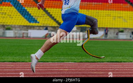 athlete runner sprinter on prosthesis running stadium track, disabled athlete para athletics competition, summer sports games Stock Photo