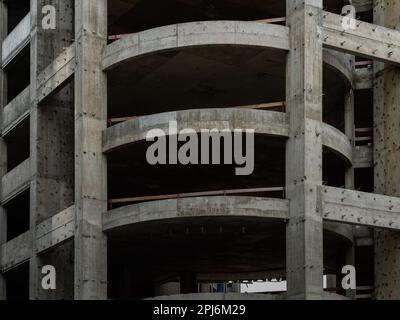 Reinforced concrete structure of a construction site. Close-up of the facade. Raw structure of the commercial building. Office complex ruin in a city. Stock Photo
