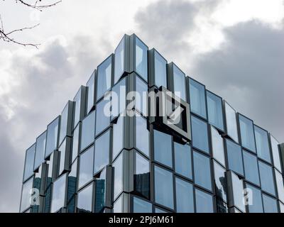 Deutsche Bank office building in front of a dramatic sky. The logo sign of the commercial investment bank is on the facade of the modern architecture. Stock Photo