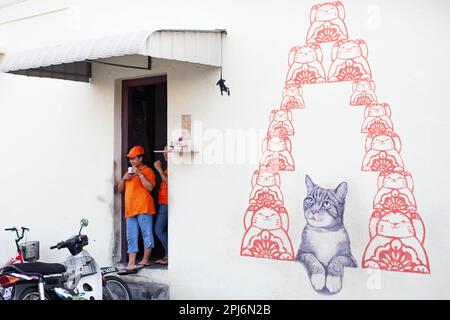 Georgetown, Penang, Malaysia - September 03, 2014: Women resting at the shop entrance at one of the main streets in historical Georgetown, Penang Stock Photo
