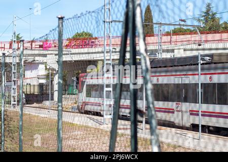 Commuter train of the community of Madrid passing through an open-air station Stock Photo