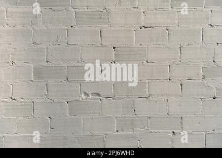 White plaster coating on bricks wall, grunge background Stock Photo