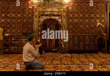 A Kashmiri Muslim man raises his hands as he prays inside a shrine on ...