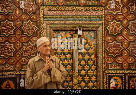 A Kashmiri Muslim man raises his hands as he prays inside a shrine on ...