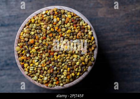 Raw organic bee pollen grains on wooden background, close up, top view, copy space Stock Photo