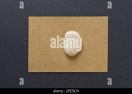 brick pebble isolated on gold or sand brown card and grey paper Stock Photo