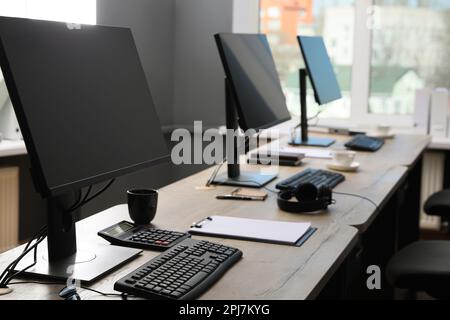 Open office interior. Modern workplaces with computers near window Stock Photo