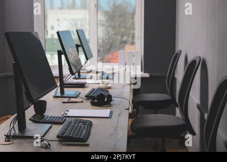 Open office interior. Modern workplaces with computers near window Stock Photo
