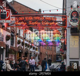 Drinking socially in Belfast people sitting drinking and talking on a wet spring day outside The Duke of York pub Belfast. Stock Photo