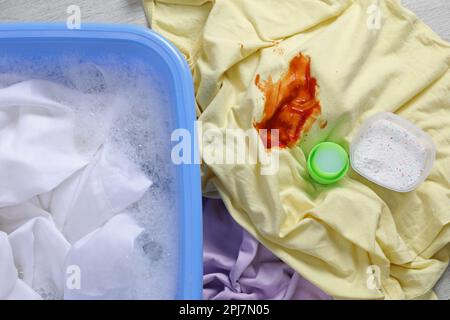 Dirty garment and detergent near basin with white shirt, top view. Hand washing laundry Stock Photo