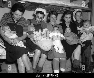 Five of the seven 'Schwangerenkommando' women, and their infants, after liberation. Seven pregnant Hungarian Jewish women were allowed to give birth at Kaufering concentration camp. Five of them are pictured here; each holding their infant; after liberation. / Kaufering I – Landsberg. Pictured from left to right are: Ibolya Kovacs with her daughter Agnes; Suri Hirsch with her son Yossi; Eva Schwartz with her daughter Maria; Magda Fenyvesi with her daughter Judit; and Boeszi Legmann with her son Gyuri. Stock Photo
