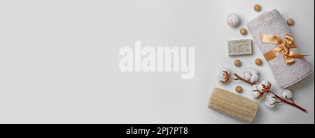 Flat lay composition with towel and toiletries on light background, space for text. Banner design Stock Photo