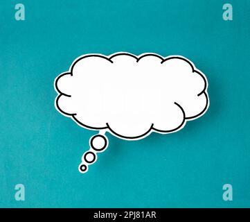 White speech bubble shaped post it note on green background with copy space. Stock Photo