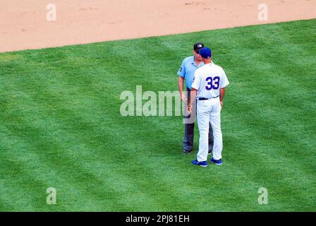 A baseball manager for the Chicago Cubs argues a call with an umpire during a game at Wrigley Field Stock Photo