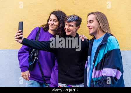 Young diverse friends taking selfies with a mobile phone outdoors. Stock Photo