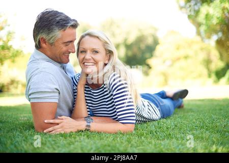 Youre the only woman for me. Full length portrait of an affectionate mature couple lying in the park. Stock Photo