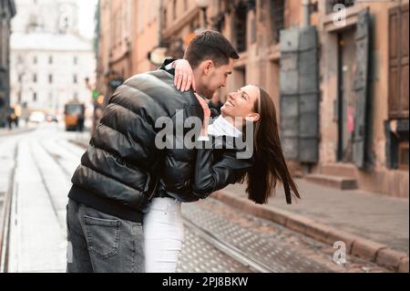 Lovely young couple walking together on city street. Romantic date Stock Photo