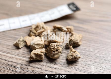 Pile of kidney stones on wooden table, closeup Stock Photo