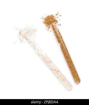 Glass tubes with pink himalayan salt and mustard seeds on white background, top view Stock Photo