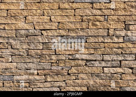 Yellow stone brick wall pattern suitable as wallpaper. Stock Photo