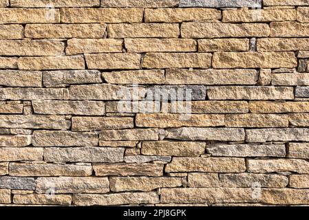 Yellow stone brick wall pattern suitable as wallpaper. Stock Photo