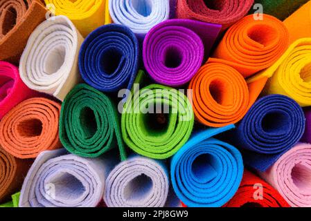 On the street, rolls of felt of different bright colors outside a shop. On the street, rolls of felt of different bright colors outside a shop. Stock Photo