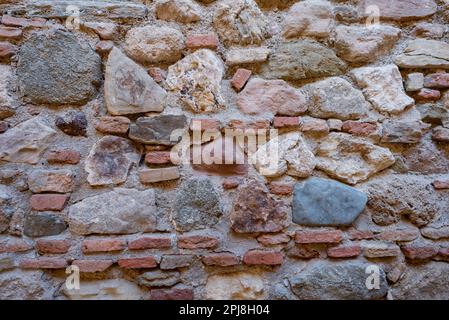 Stone and brick wall of an ancient building. Suitable as background and wallpaper pattern. Stock Photo