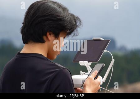 Drone remote control operation while using a phone Stock Photo