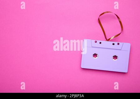 One purple cassette on a pink background. Music day, top view Stock Photo