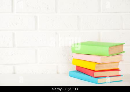 Multi coloured school books on a white background with copy space. Top view Stock Photo