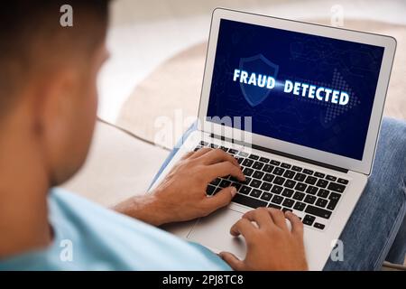 Fraud prevention security system. Man using laptop at home, closeup Stock Photo